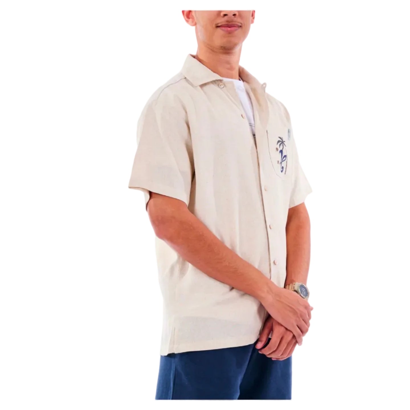 Man wearing a beige short-sleeve shirt with embroidery on a white background