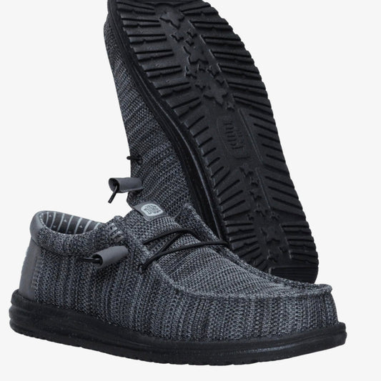 Gray knit shoe with black sole on a white background