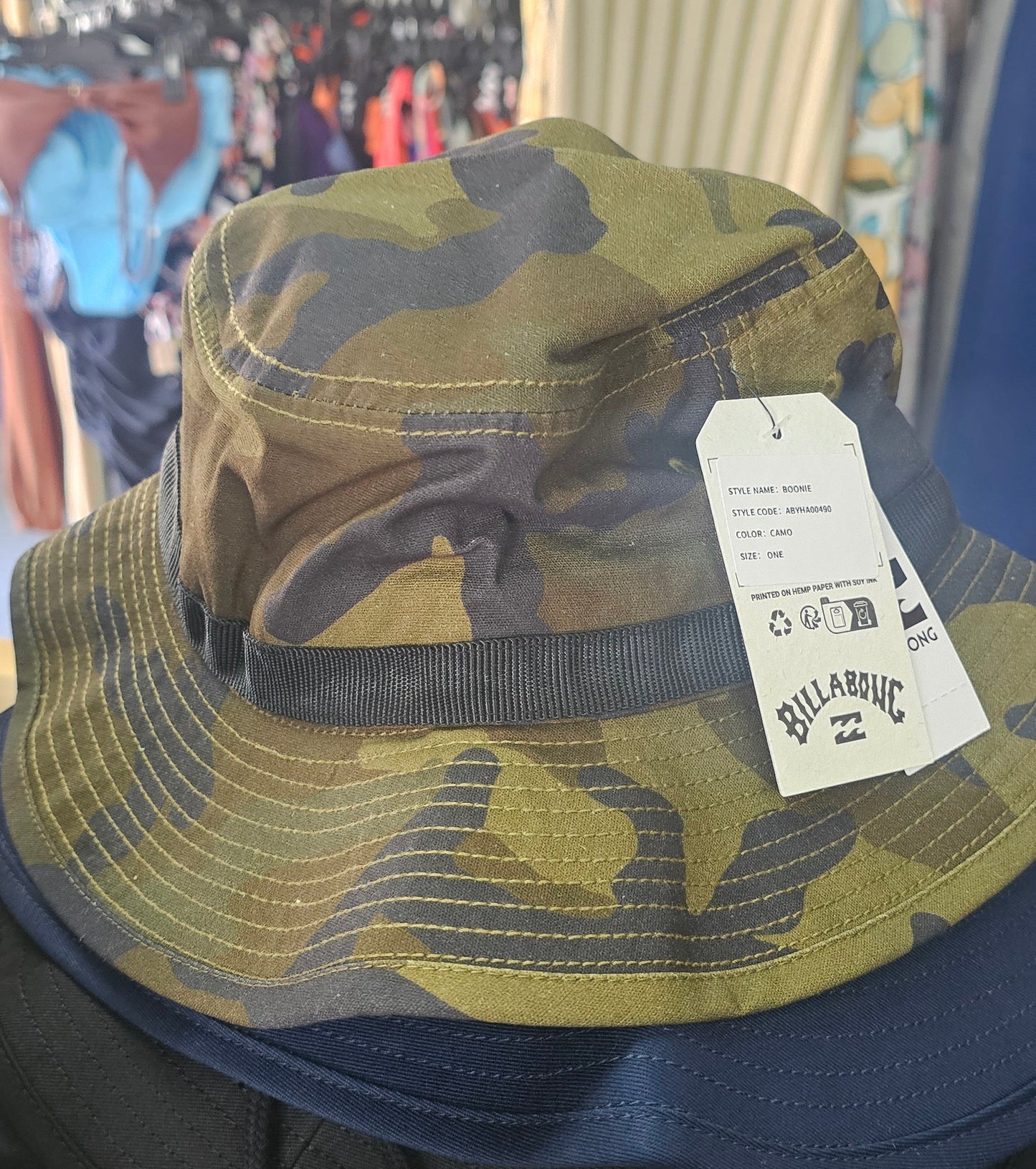 Camouflage bucket hat with a Billabong tag on a blurred background
