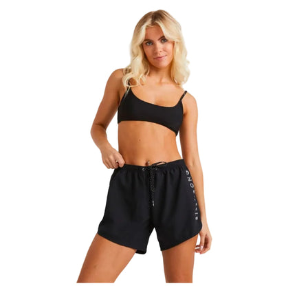 Woman wearing a black sports bra and shorts on a white background
