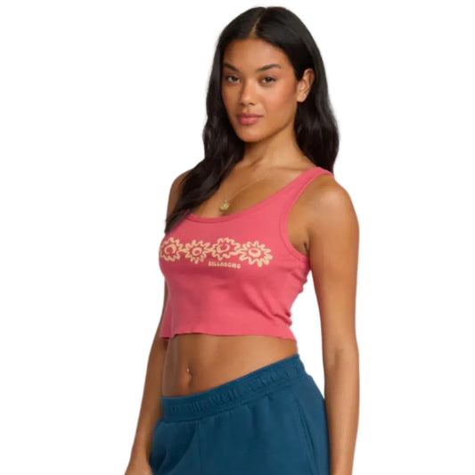 Woman wearing a pink crop top with floral design and text, standing against a plain background