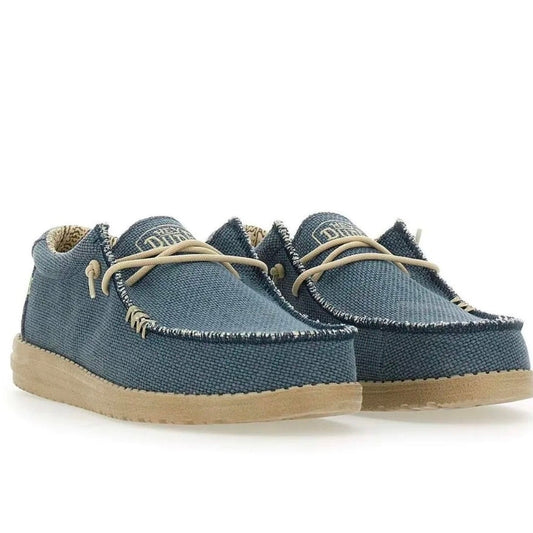 A pair of blue canvas slip-on shoes with beige laces and a light tan sole, shown on a white background.