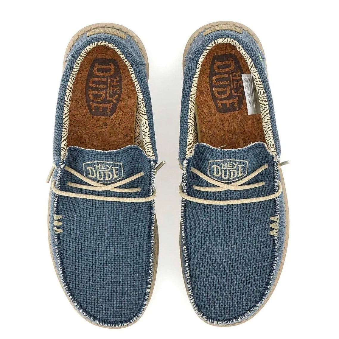 A pair of Vans 'Hey Dude' slip-on canvas shoes in a dusty blue color, shown from a top-down view on a white background.