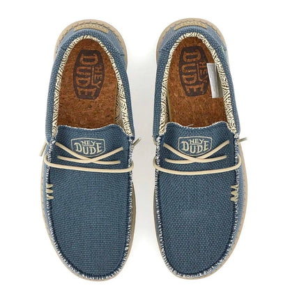 A pair of Vans 'Hey Dude' slip-on canvas shoes in a dusty blue color, shown from a top-down view on a white background.