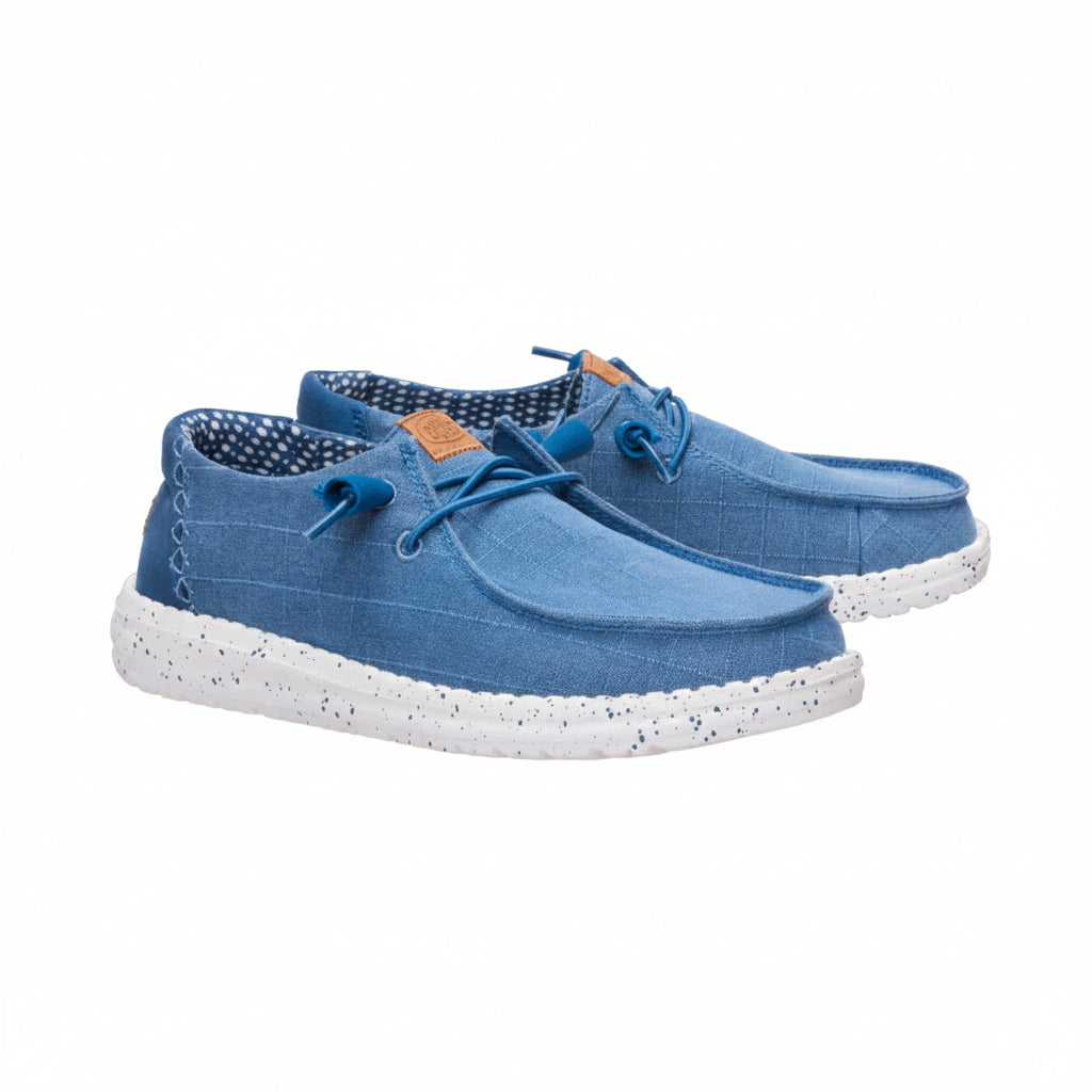A pair of blue canvas lace-up shoes with white speckled soles, shown against a plain white background.