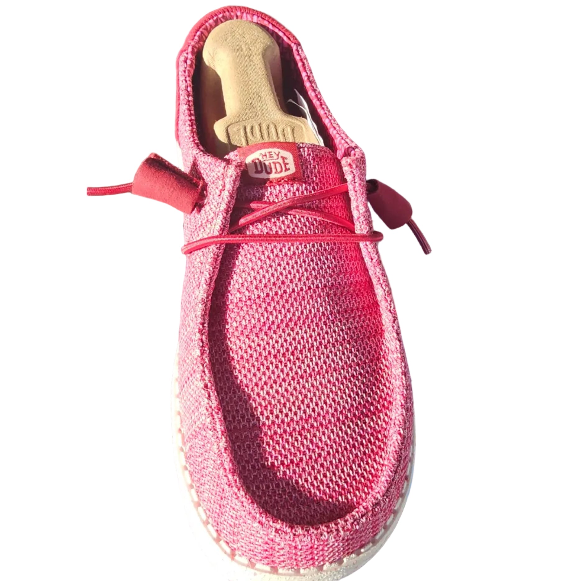 A pink knit slip-on shoe with red laces and a white sole, shown alongside its blue and white box.