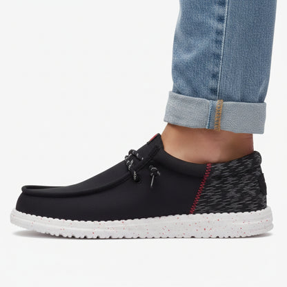 Black slip-on shoe with white sole on a white background