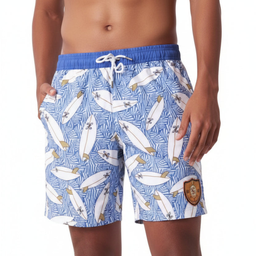 Blue swim shorts with fish pattern worn by a person on a white background
