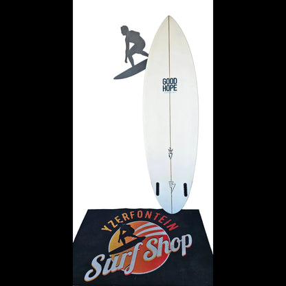 Surfboard with 'Good Hope' branding on a surf shop mat.