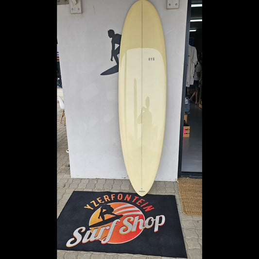 Beige surfboard mounted on a wall with a black and orange logo in the background.