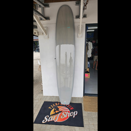 Longboard on a white surface with a branded mat in the background