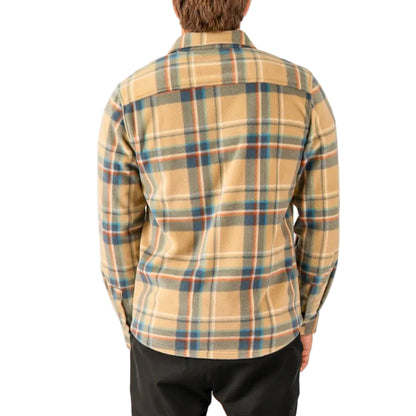 Person wearing a plaid shirt with a neutral color palette on a white background