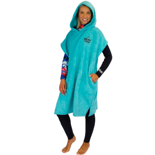 Person wearing a turquoise hooded poncho with Reef branding on a white background