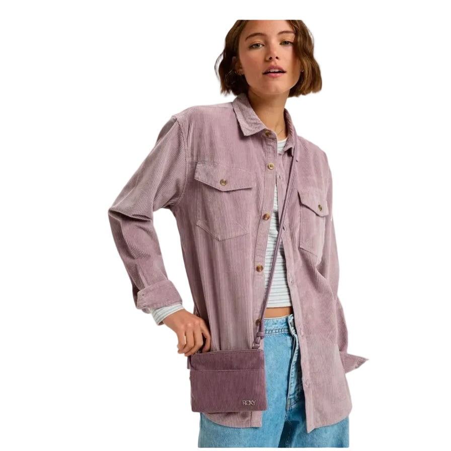 Woman wearing a long, light purple corduroy shirt with a white background