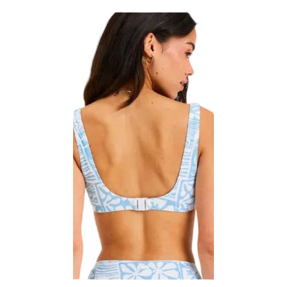 Woman wearing a blue and white patterned bikini with a plain background