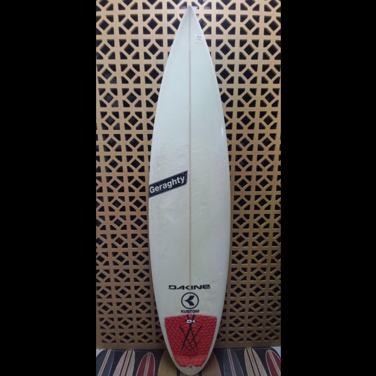 White surfboard with visible branding on a patterned background