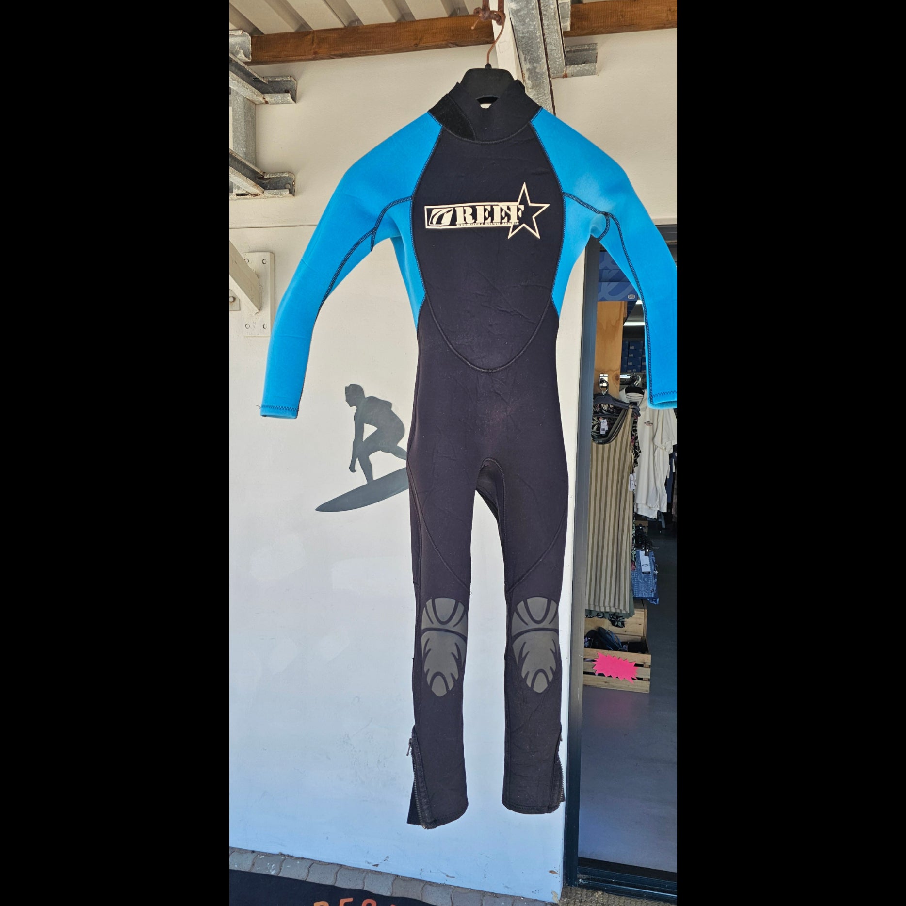 Black and blue wetsuit on a white surface with a blurred background