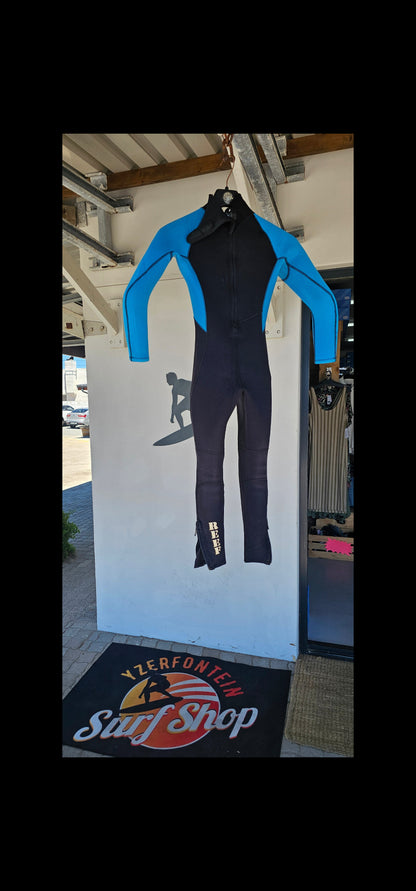Black pants with blue waistband on a white surface, with a blurred background