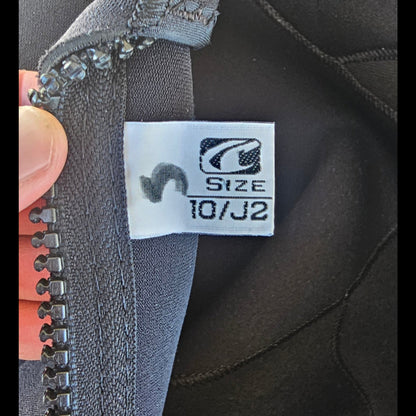 Close-up of a size label on a piece of gray fabric with a zipper.