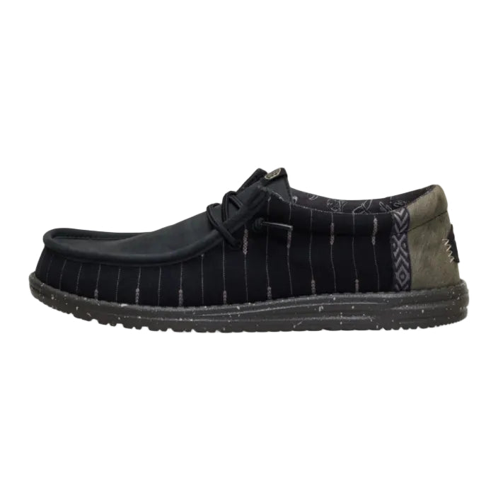 Black shoe with a patterned sole on a white background