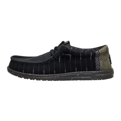 Black shoe with a patterned sole on a white background