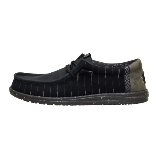 Black shoe with a patterned sole on a white background