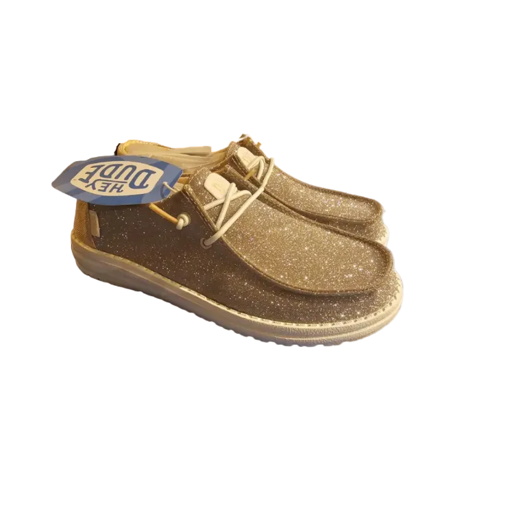 Gold glittery shoes with a visible brand tag on a white background
