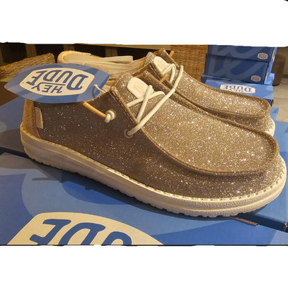 Brown glittery shoe with a blue Dune label on a blue surface.