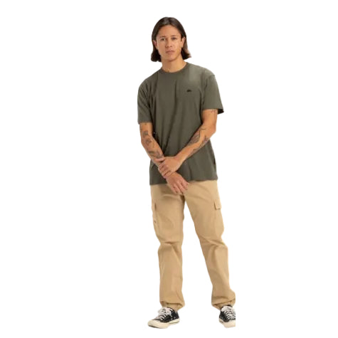Person wearing a green t-shirt and beige pants on a white background