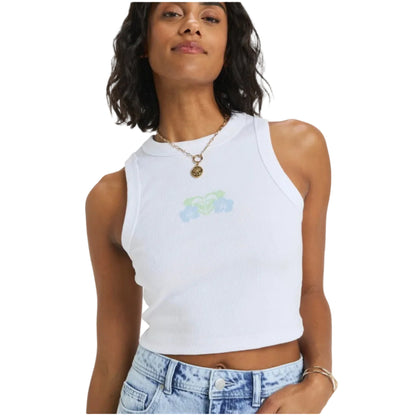 Woman wearing a white sleeveless top with a small design on a plain background