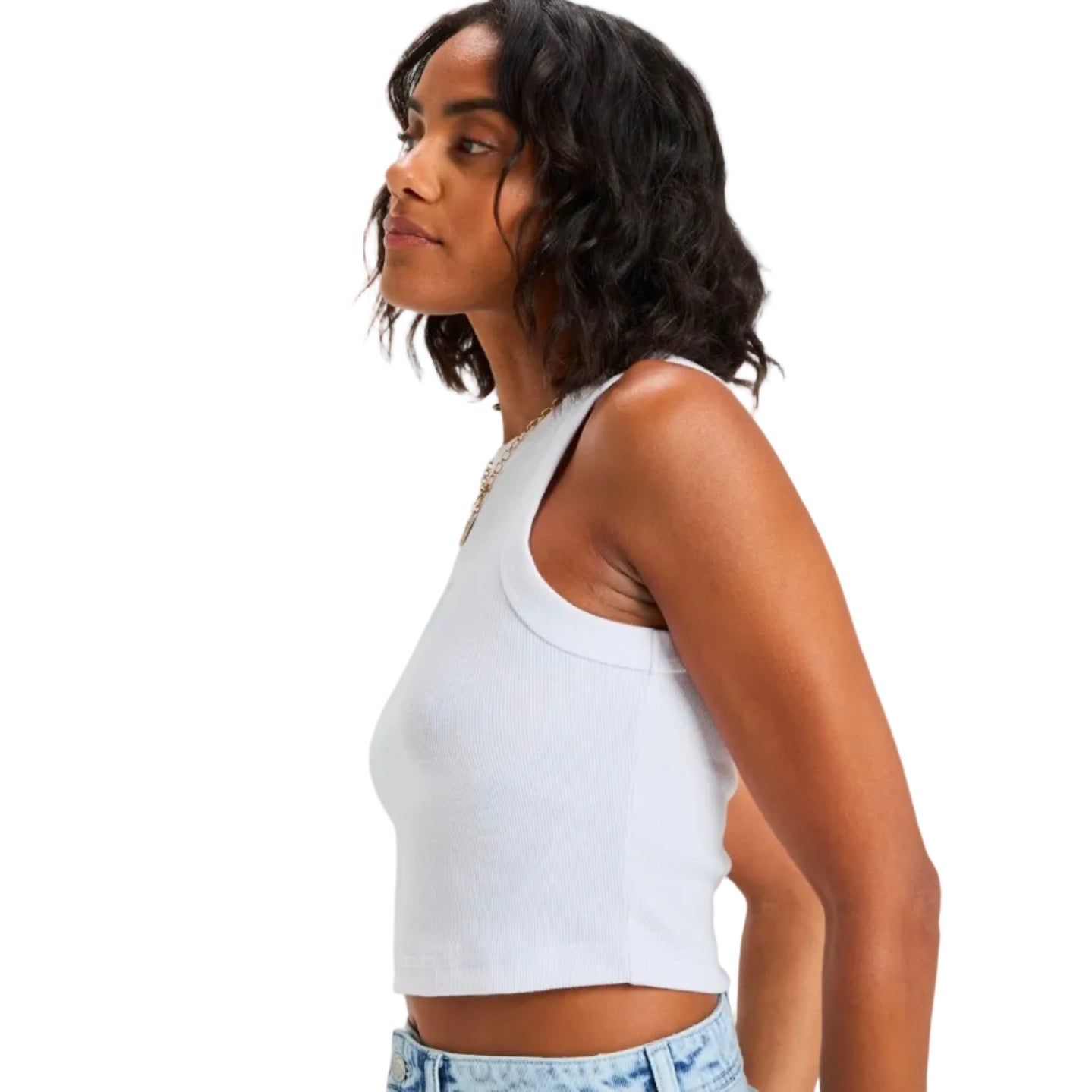 Woman wearing a white tank top and denim shorts on a plain background