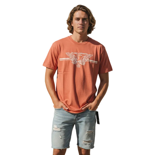 Orange t-shirt with a graphic design on a patterned surface